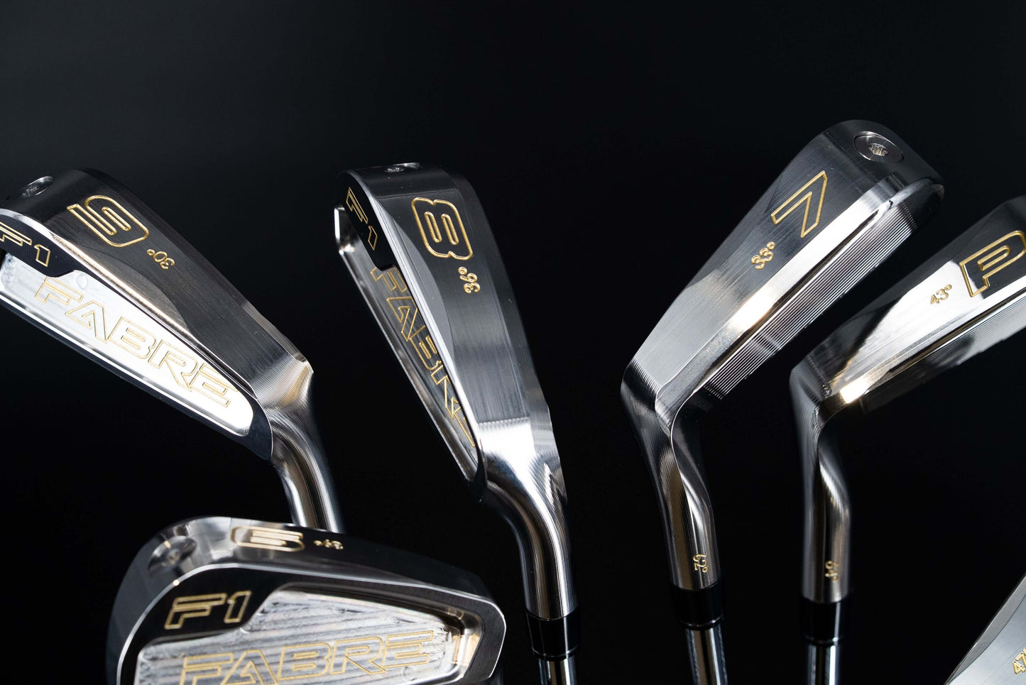 Fabre F1 Irons displayed on a black background, showcasing precision design and craftsmanship for enhanced golf performance.